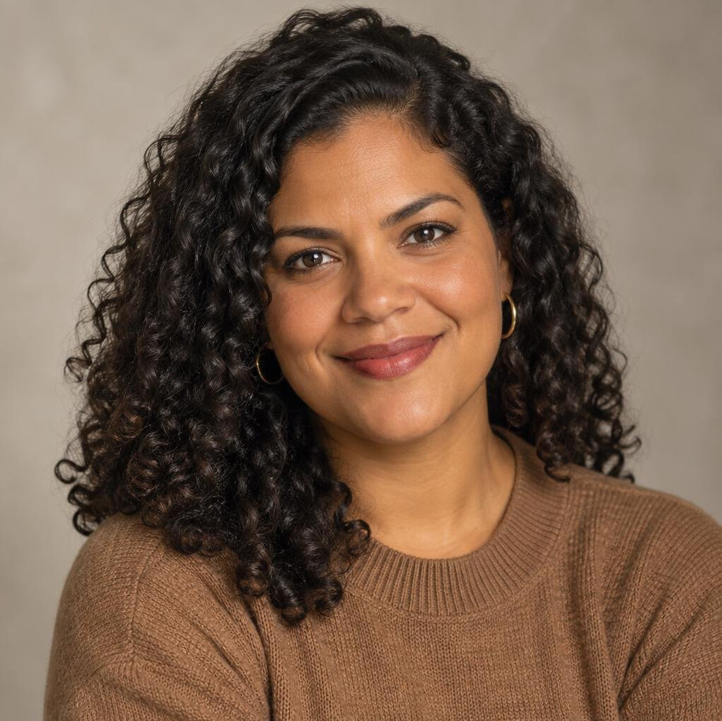 Portrait of a Brazilian woman with curly hair smiling warmly